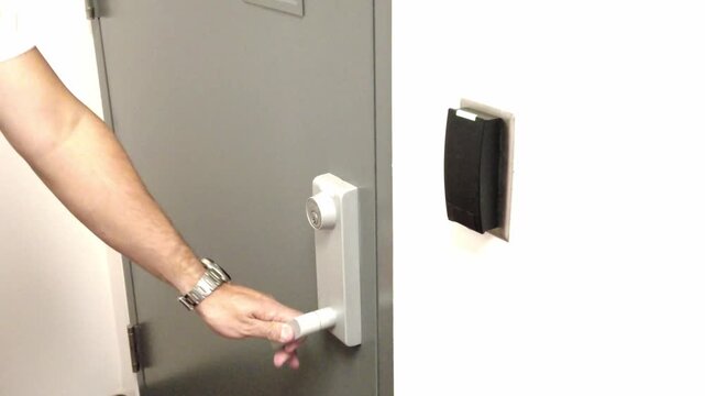 Employee using key card access control system to open office door