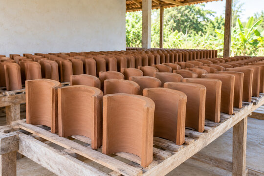Unglazed Terracotta Roof Tiles Air Drying on Wooden Racks