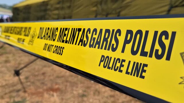 Yellow Indonesian police line tape with DO NOT CROSS and POLICE LINE text.