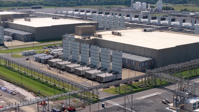 Massive data center showing large server buildings, rows of mechanical equipment, overhead utility systems and surrounds service roads, aerial view in Clarksville, Tennessee