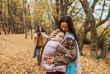 Fototapeta premium Family portrait of parents with two daughter, in the middle of autumn forest.