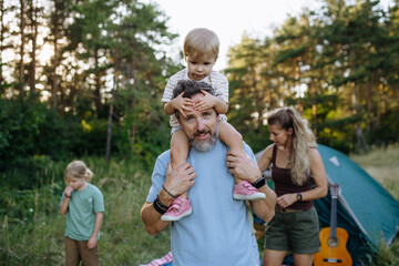 Naklejka premium Happy family spending time together during summer camping trip.