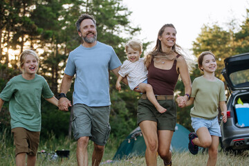 Naklejka premium Happy family spending time together during summer camping trip.