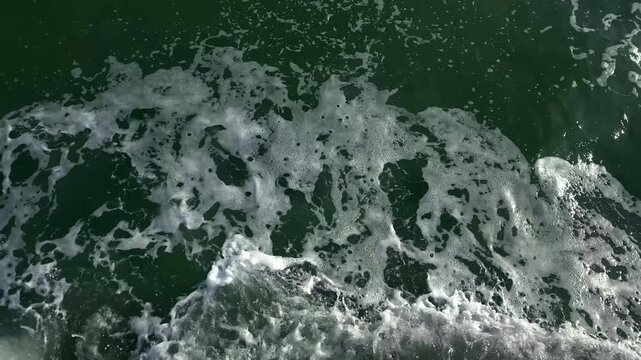White foam patterns move across dark seawater in a close view, supporting marine observation, coastal water studies and educational content about wave driven surface processes in the Black Sea