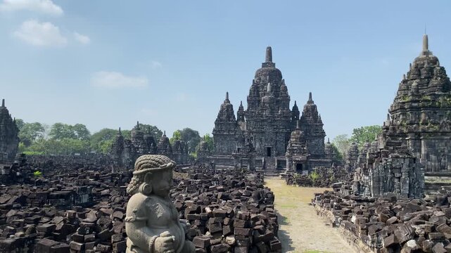 Ancient Sewu Buddhist temple stone ruins with ornate stupas under a clear blue sky in Central Java, Indonesia on a bright sunny day.