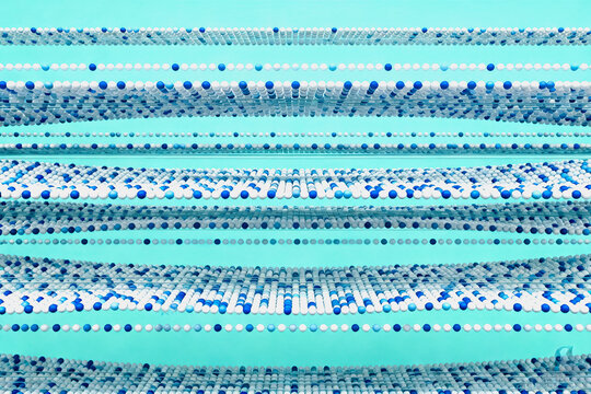 Parallel linear bead structures with blue and white elements set against a light turquoise background, forming an abstract patterned composition.