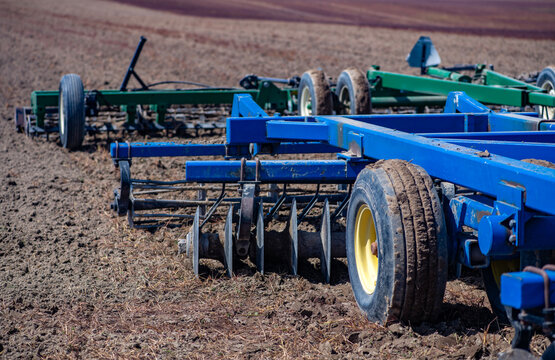 Harrow machinery prepares plowed field soil. Heavy harrow improves farm cultivation work. Rural agriculture uses harrow on land. Outdoor fieldwork needs harrow equipment.