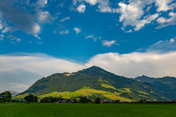 Naklejka premium Mountain scenery across the Swiss Alps. Mountain panorama under deep blue sky. Swiss travel landscape with mountain and clouds. European Alps tourism around mountain countryside.