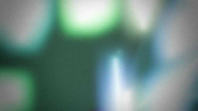 Soft blurred green and teal light flares with grainy glow