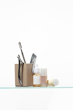 Complete nail technician kit with metal precision tools and nourishing serum. Perfect for professional salon branding, showcasing cuticle care, nail shaping, and moisturizing hand treatments.