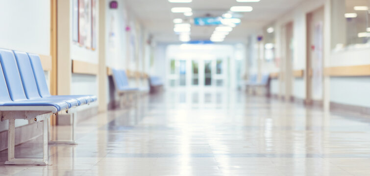 Hospital waiting area with empty blue chairs, long corridor blurring into bright entrance, healthcare concept