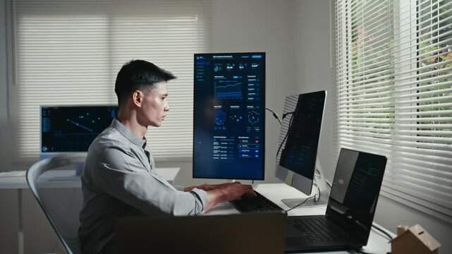 Financial data analyst programming and coding on multiple computers