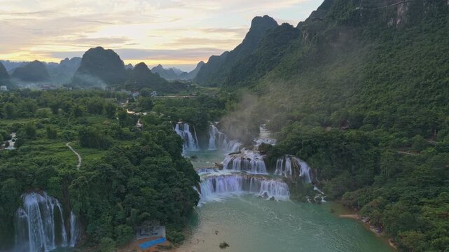 Majestic aerial view of the ban gioc detian waterfalls on the border of vietnam and china, cascading down lush green mountains at sunset