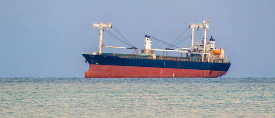 Large cargo ship sailing near the Strait of Hormuz, highlighting global energy transportation and international maritime trade. © Asanee