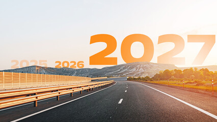 Fototapeta premium Road leading into the future marked by years 2025, 2026, and 2027 along a highway with mountains in the background