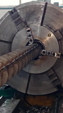 Close view of a rotating lathe chuck in metal workshop