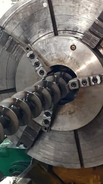 Lathe chuck turning a long threaded steel shaft