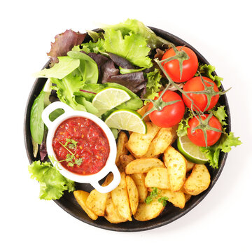 Crispy potato wedges with tomato salsa dip and fresh salad top view