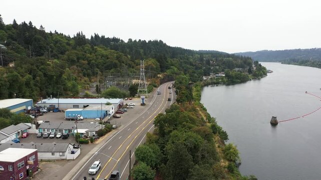 4K aerial drone footage of Oregon City near Portland, Oregon, USA, showing Highway 99E, electrical power substation, Willamette River, forested hills, residential neighborhoods and roads in cloudy day