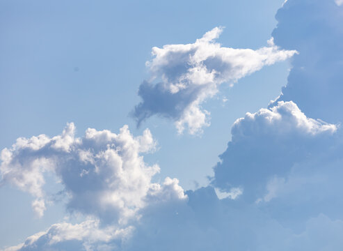 Soft white clouds drift against a clear blue sky
