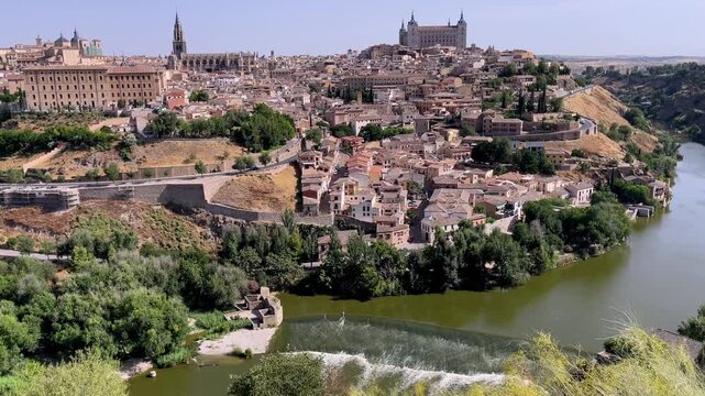 panoramic view of toledo medieval city skyline with alcazar cathedral and tagus river under clear blue sky in castile la mancha spain