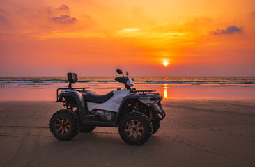Quad bike At twilight sky sunset on the tropical beach. ATV quad tracks on the golden beach sand © Elena_Alex