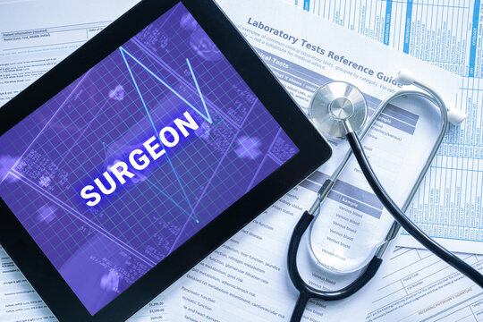 SURGEON text on digital tablet screen with stethoscope and documents
