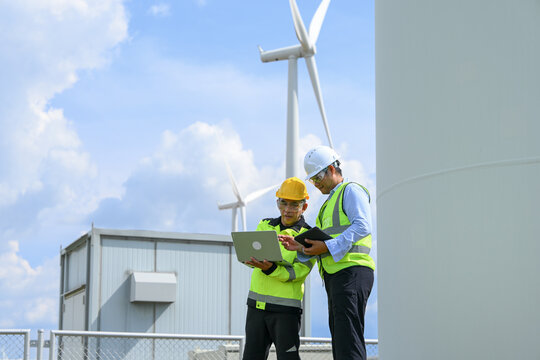 Electrical engineer wind turbine renewable energy industrial worker safety helmet high visibility vest digital tablet