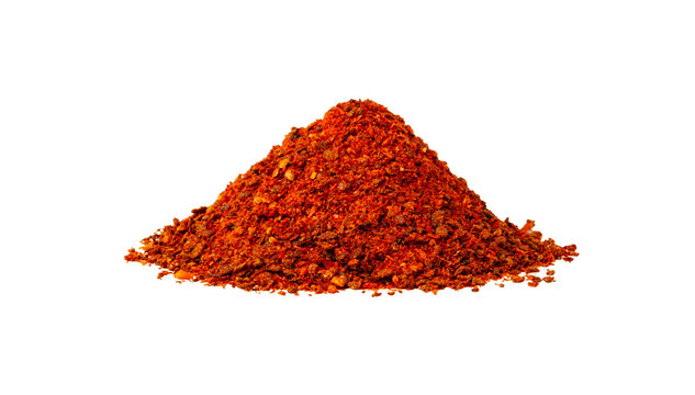 Red chili powder piled on a white background showing texture and color