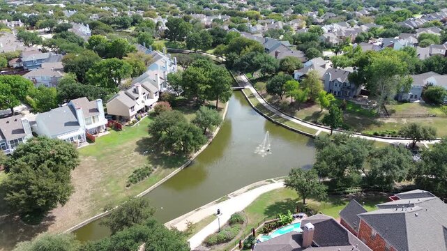 Bubbling fountains activate lagoons, sending sparkling mist upward along Valley Ranch Waterways. Manicured hedges edge concrete paths, enhancing tranquil outdoor retreats. . USA, Irving, Texas