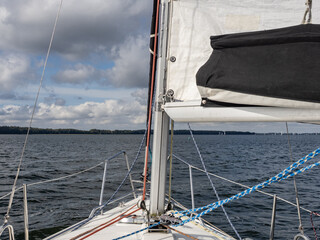 Sailboat Deck and Mast Facing Open Water Under Dramatic Clouds During Leisure Sailing on a Masurian Lake © Michał Kiełbicki