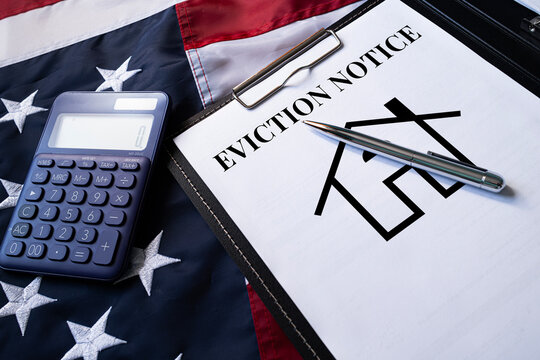 Eviction Notice document with calculator and house sketch on desk, real estate and tenant housing law concept