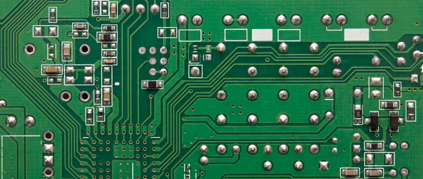 Circuit board with soldered components and tracks, showing green substrate, silver solder joints, and conductive copper lines for hardware repair, engineering, and digital technology concepts