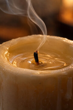 Warm wax ripples beside a newly extinguished candle wick