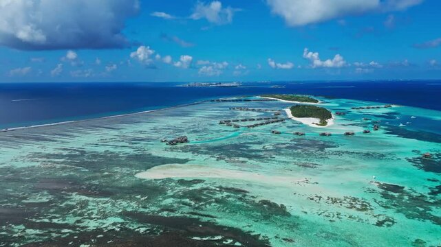 Panoramic drone shot of paradise tropical islands surrounded by turquoise coral reef lagoon. Perfect establishing scene for luxury travel promo, vacation and cruise agency.