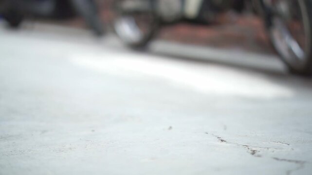 Hand taking rubber slide sandals from floor. Relaxed everyday footwear themes.