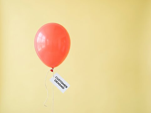 Red balloon floating with customer demand tag suitable for business marketing content symbolizing rising market expectations and economic growth