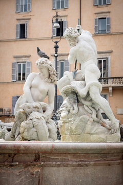 Detail view of Neptune fighting an octopus and sea nymph with a pigeon on her head at Fontana del Nettuno in Piazza Navona, Rome, Italy