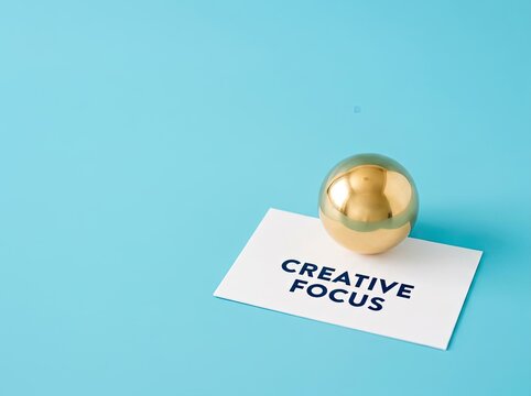 Golden sphere on card with CREATIVE FOCUS text on blue backdrop ideal for branding design symbolizing clarity innovation and strategic focus