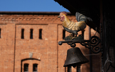 Vintage Cast Rooster Doorbell Mounted Outside Old Red Brick Building. The old Welcome Bell cock-bell © Hanna Aibetova
