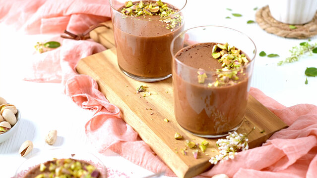A close-up of chocolate mousse with pistachios and a spoon