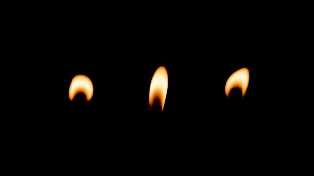 One burning candle on black background, closeup. Christmas concept and happy New Year.