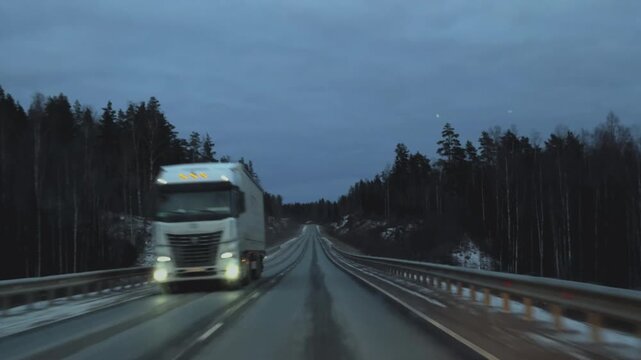 Snowy highway, difficult road conditions in winter. POV driving along an asphalt through a snow-covered forest in winter. First-person view from inside a moving car, capturing a scenic snowy landscape