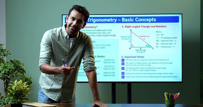 Young Indian male mathematics teacher explaining trigonometry on a large digital TV whiteboard for online classes, covering math education, geometry and modern e-learning.