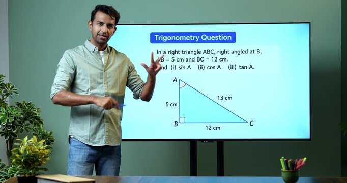 Young Indian male mathematics teacher explaining trigonometry on a large digital TV whiteboard for online classes, covering math education, geometry and modern e-learning.