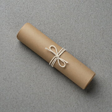 Rolled kraft paper tied with unbleached cotton twine on limestone slab