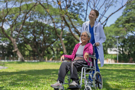 Nurse assisting senior woman in wheelchair outdoors, promoting health and mobility