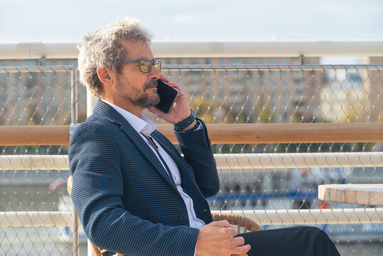 Portrait of attractive senior man with smartphone outdoor in the city
