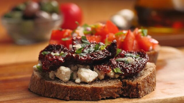 Italian sandwich bruschetta with sun dried tomatoes, fresh tomatoes and cream cheese, close up of Italian appetizer on farm bread with olive oil, Spanish tapas and pinchos