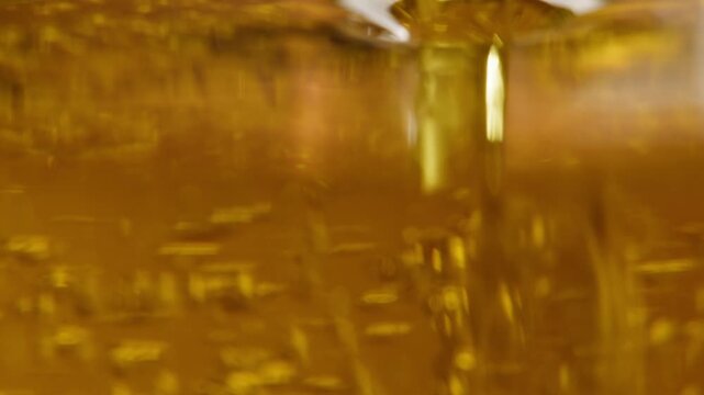 Olive oil and flax oil pouring stream macro close up, golden extra virgin olive, sunflower, flaxseed or sesame oil flowing, Italian, Spanish and Asian cooking